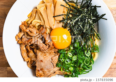 豚肉と生卵をのせた油そば 木製テーブルの上の手作りまぜそば 137835096