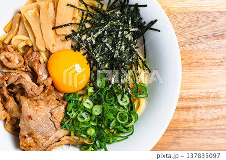 豚肉と生卵をのせた油そば 木製テーブルの上の手作りまぜそば 137835097