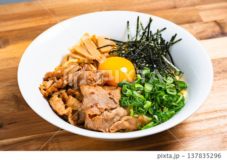 豚肉と生卵をのせた油そば 木製テーブルの上の手作りまぜそば 豚肉と生卵をのせた油そば 木製テーブルの上の手作りまぜそば 137835296