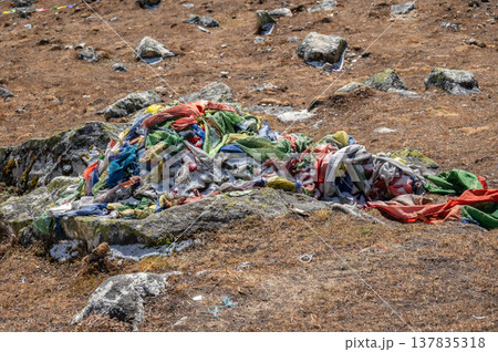Old, tattered prayer flag debris on mountain in Langtang national park, Nepal. That should be treated with respect, as they are considered sacred, representing living prayers that have faded over time Old, tattered prayer flag debris on mountain in Langtang national park, Nepal. That should be treated with respect, as they are considered sacred, representing living prayers that have faded over time 137835318