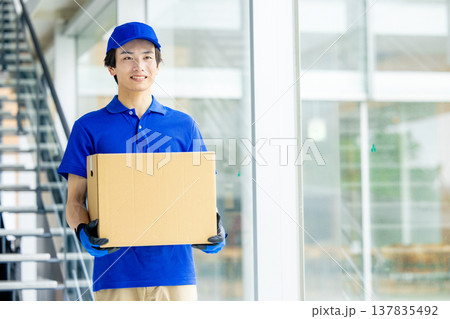 荷物を運ぶ笑顔の男性 137835492