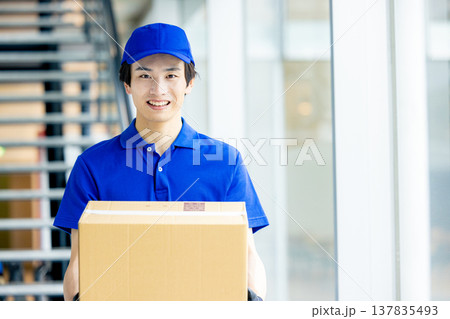 荷物を運ぶ笑顔の男性 137835493