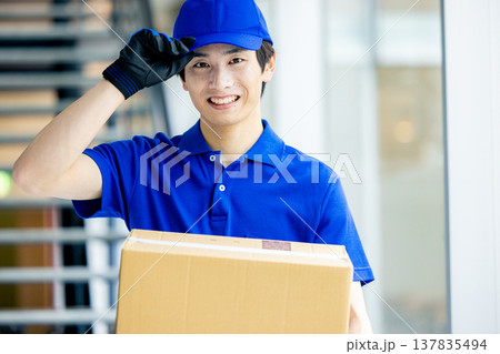 荷物を運ぶ笑顔の男性 137835494