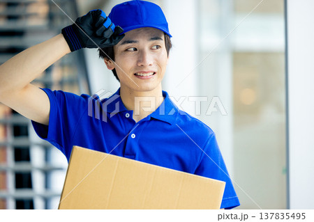 荷物を運ぶ笑顔の男性 荷物を運ぶ笑顔の男性 137835495