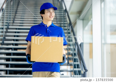 荷物を運ぶ笑顔の男性 荷物を運ぶ笑顔の男性 137835500