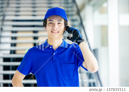倉庫でスマホを持つ作業員の男性 倉庫でスマホを持つ作業員の男性 137835511