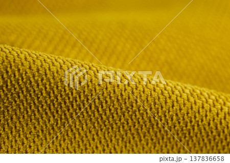 Macro view of mustard yellow heavy-knit textile showing intricate loops and fiber depth Macro view of mustard yellow heavy-knit textile showing intricate loops and fiber depth 137836658