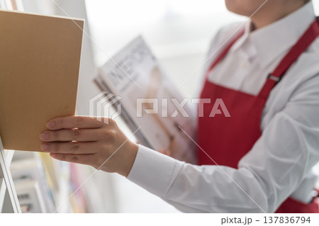 雑誌を手に取る書店スタッフ 雑誌を手に取る書店スタッフ 137836794