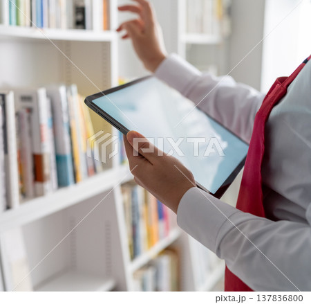 タブレットを操作して棚を確認する店員 137836800