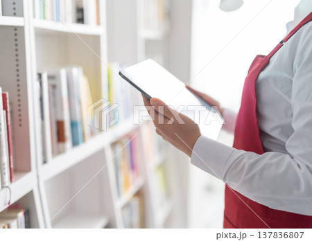 棚の前でタブレットを持つ店員 棚の前でタブレットを持つ店員 137836807