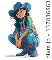 Cowgirl hat boots denim colorful shirt squatting confident young woman western style fashion outdoors relaxed casual vibrant long hair hoop earring rural countryside attitude modern trendy 137836863