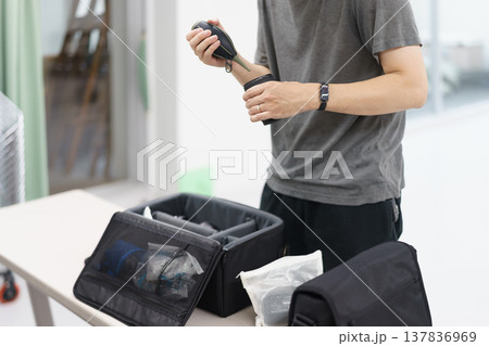 室内でTシャツを着て撮影の準備をする人物の上半身 137836969