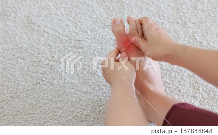 Woman massaging painful foot and toe with red highlight. Foot pain, plantar fasciitis, gout, arthritis and peripheral neuropathy concept for health care, physical therapy and medical treatment. Woman massaging painful foot and toe with red highlight. Foot pain, plantar fasciitis, gout, arthritis and peripheral neuropathy concept for health care, physical therapy and medical treatment. 137838848