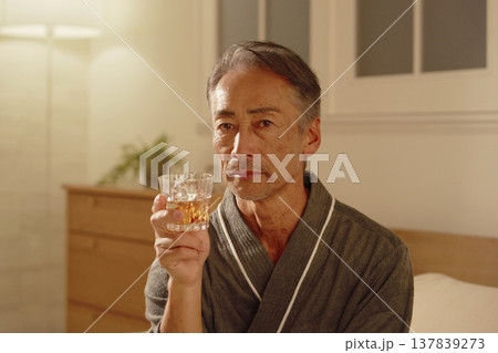寝室でウイスキーを飲むシニア男性 ポートレート カメラ目線 寝室でウイスキーを飲むシニア男性 ポートレート カメラ目線 137839273