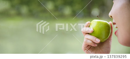 Banner young asian woman bite green Apple Healthy. Girl workout holding organic apple fruit healthy lifestyle. Banner close up women hands holding green apple. Women dieting lifestyle with copy space Banner young asian woman bite green Apple Healthy. Girl workout holding organic apple fruit healthy lifestyle. Banner close up women hands holding green apple. Women dieting lifestyle with copy space 137839295