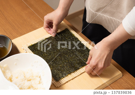 恵方巻きを作る女性の手元クローズアップ 恵方巻きを作る女性の手元クローズアップ 137839836
