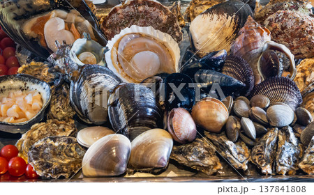 新鮮なホタテや牡蠣が山盛りに並ぶ豪華な海鮮貝類の盛り合わせ 137841808