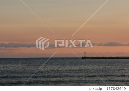 日没時に腰越海岸から見るオレンジ色に染まる江ノ島付近の風景 137842649