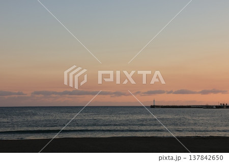 日没時に腰越海岸から見るオレンジ色に染まる江ノ島付近の風景 137842650