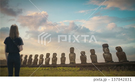 Woman Looking at Moai Statues on Easter Island at Sunset with copy space 137842831