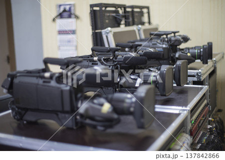 Professional Broadcast Video Cameras in Row on Cases in Studio with copy space 137842866