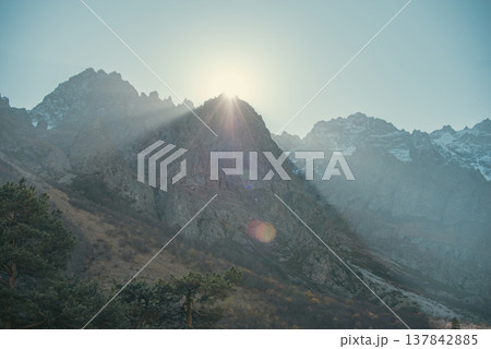 Majestic Sunrise Behind Mountain Peak with Bright Sunrays and copy space 137842885