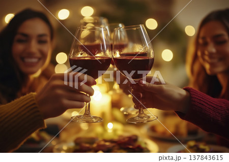 Friends toasting red wine at dinner party 137843615