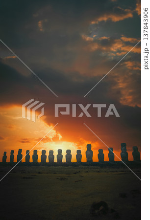 Ancient Moai statues silhouettes at Ahu Tongariki sunset on Easter Island with copy space Ancient Moai statues silhouettes at Ahu Tongariki sunset on Easter Island with copy space 137843906