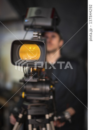 Professional broadcast camera in news studio with orange lens reflection and copy space 137844292
