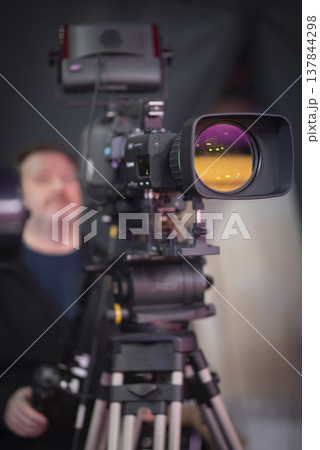 Professional broadcast camera in news studio with amber lens reflection and copy space 137844298