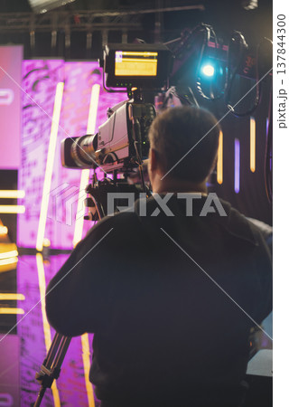 Professional cameraman in news studio with broadcast camera and copy space 137844300
