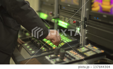Professional engineer hand on video switcher control panel in news studio with copy space 137844304