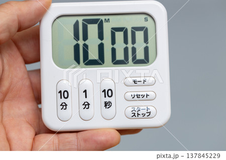 10分にセットされたキッチンタイマーを手に持っている 137845229