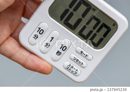 10分にセットされたキッチンタイマーを手に持っている 137845230