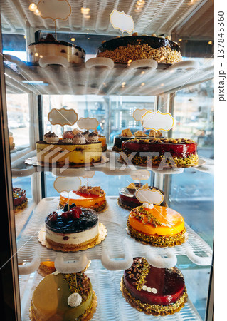 Display showcases various cakes in a bakery on a sunny day Display showcases various cakes in a bakery on a sunny day 137845360
