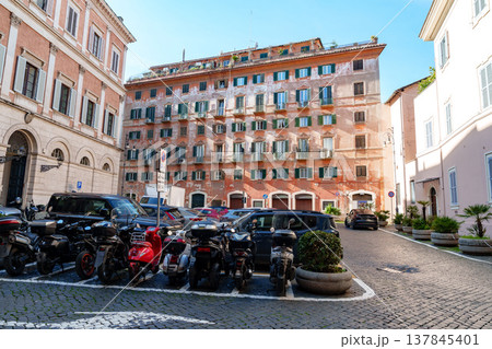 Cars and motorcycles are parked in a square in Rome on a sunny day with clear skies 137845401