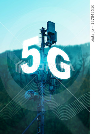 5G internet tower stands tall against a clear sky and green hills during the day 137845516