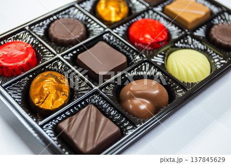 Closeup of Chocolates in various shapes in beautiful premium packaging boxes on white background 137845629