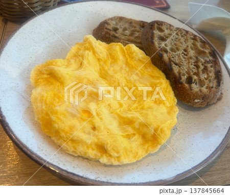 Egg omelette on a plate with rye bread 137845664