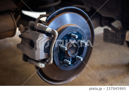 The car's wheels were removed, exposing the discs and disc brakes for tire changes and repairs. 137845993