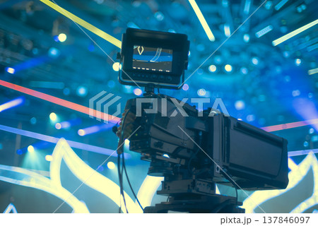 Professional Broadcasting Camera on Tripod Filming Live Neon Show with copy space 137846097