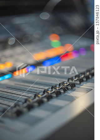 Professional Mixing Console Faders Close-up with Colorful Bokeh and Copy Space 137846123