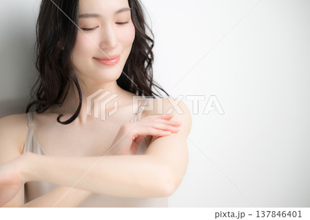 腕にクリームや日焼け止めを塗る美容イメージ　白背景 137846401