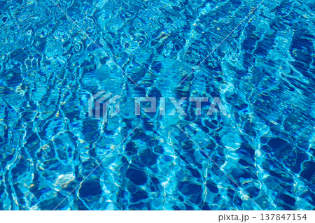 Clear blue water ripples under sunlight, creating a series of shimmering patterns and reflections, enhancing the calm atmosphere of the area. Clear blue water ripples under sunlight, creating a series of shimmering patterns and reflections, enhancing the calm atmosphere of the area. 137847154