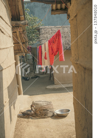 Traditional Mud House Courtyard in Rural India with Colorful Laundry and Copy Space 137848010