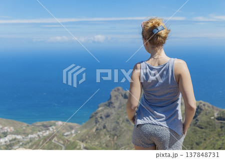 Young woman traveler admiring scenic Atlantic ocean and mountain view from high viewpoint with copy space Young woman traveler admiring scenic Atlantic ocean and mountain view from high viewpoint with copy space 137848731