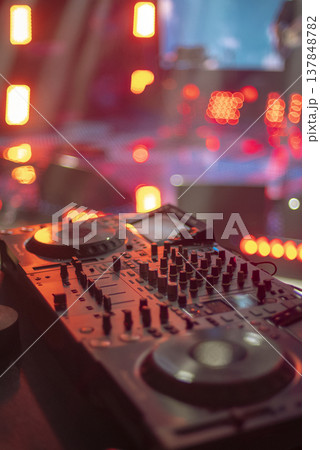 Professional DJ Deck with Red Stage Lighting and Large Copy Space on Blurred Bokeh Background Professional DJ Deck with Red Stage Lighting and Large Copy Space on Blurred Bokeh Background 137848782