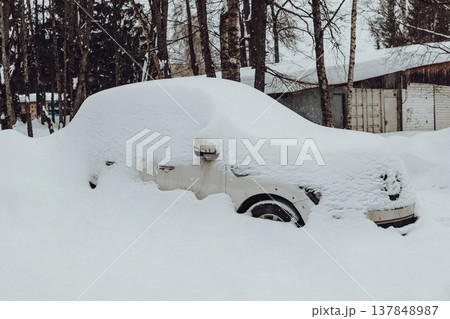 Parking of cars covered with snow. Heavy snowfall covered the road. Car in the snow. Consequences of a snowstorm.Abandoned car on the side of the road. Parking of cars covered with snow. Heavy snowfall covered the road. Car in the snow. Consequences of a snowstorm.Abandoned car on the side of the road. 137848987