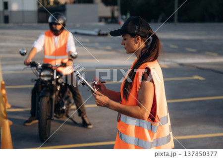 Motorcycle driving license exam. Man and woman are in uniforms 137850377