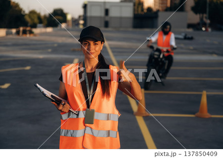 Thumb up hand gesture. Motorcycle driving license exam. Man and woman are in uniforms 137850409